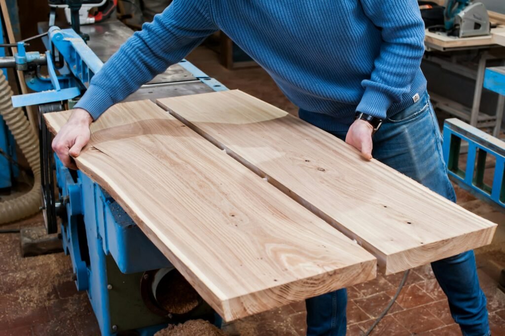 Man gluing planks in a carpentry workshop